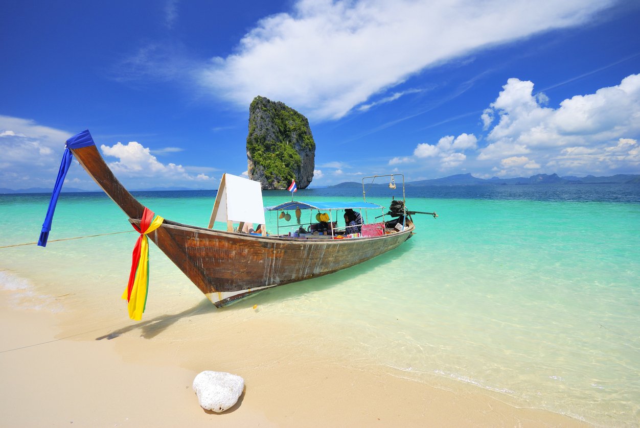 Beste Reiseziele in Asien - Thailändisches Longtailboat im glasklaren meer