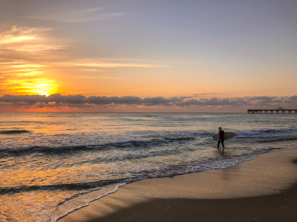 Ein Surfer am Strand in Cancun bei Sonnenuntergang