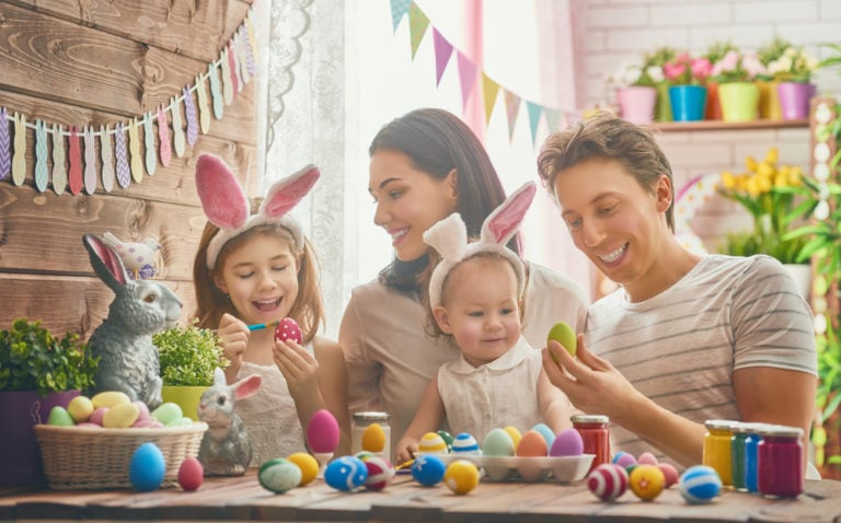 Fröhliche Familie feiert bunte Ostern