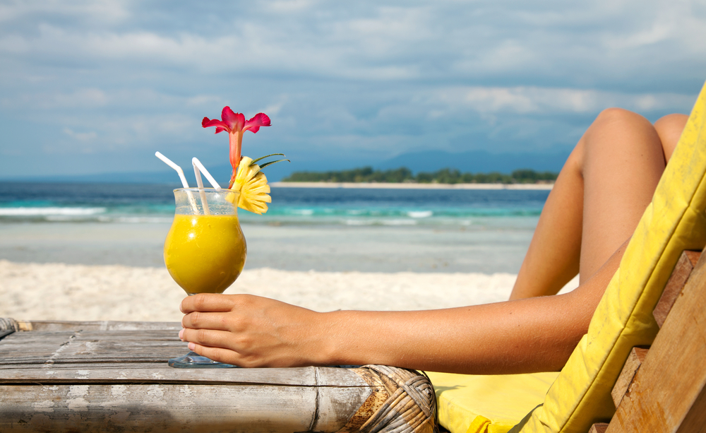 Frau mit Cocktail am Strand auf den Gili Inseln