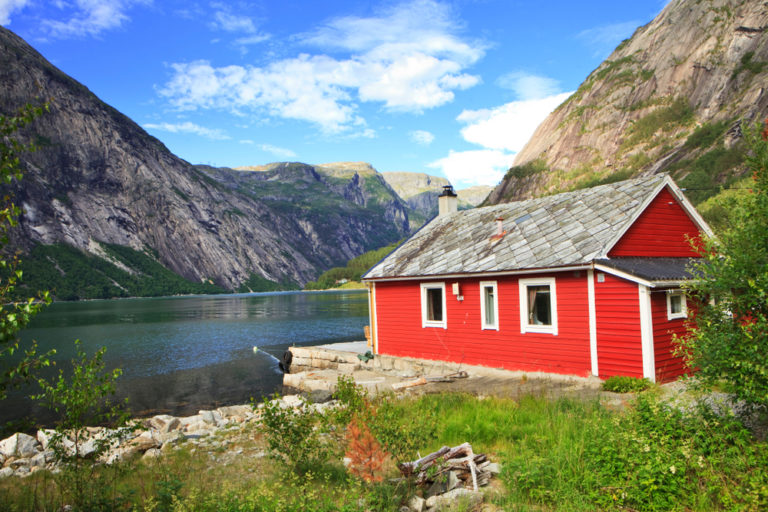 Typisch rote Holzhütte am Fjord in Norwegen