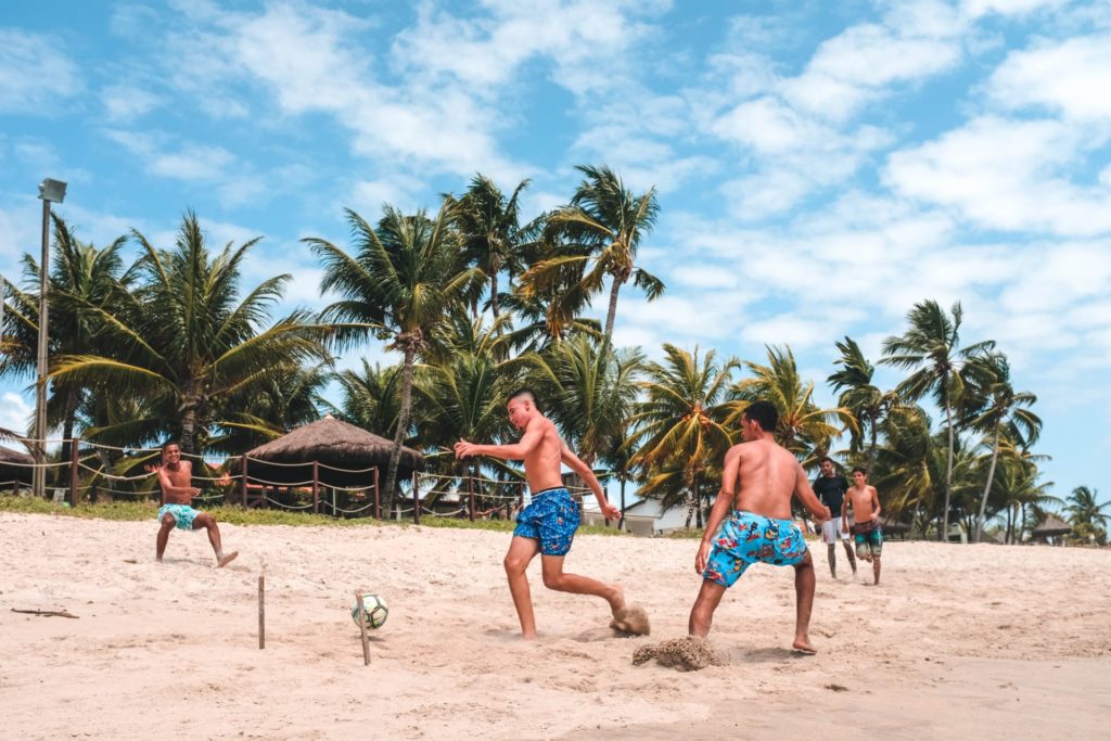 Kinder spielen Fußball am Praia de Maracaípe, Brasilien