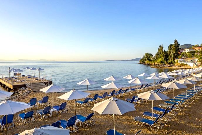Sonnenliegen und Schirme am Strand des Aeolos Beach Resort auf Korfu