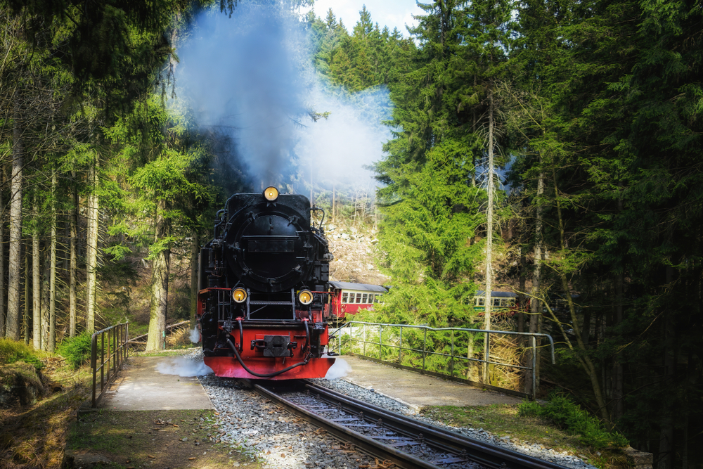 Schwarze alte Eisenbahn mitten im Harz umgeben von Wald