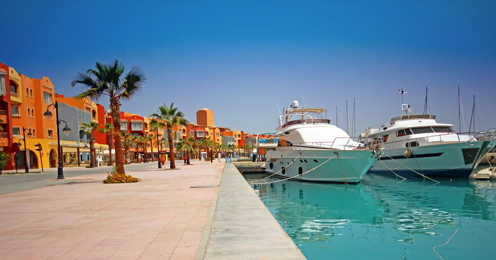 Marina in Hurghada mit orangefarbenen Gebäuden und Motoryachten