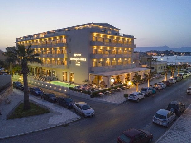Beleuchtetes Hotelgebäude des Mayor Mon Repos Palace Hotels in Korfu Stadt