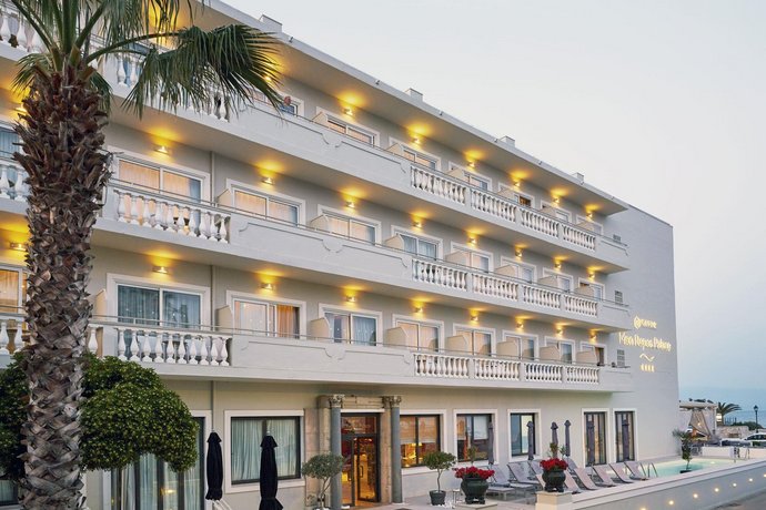 Beleuchtetes Hotelgebäude des Mayor Mon Repos Palace Hotel in Korfu Stadt am frühen Abend