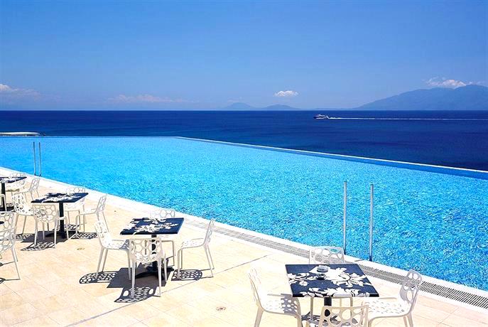 Blick auf den Pool des Michelangelo Resort und Spa Kos mit Meer und Landschaft im Hintergrund