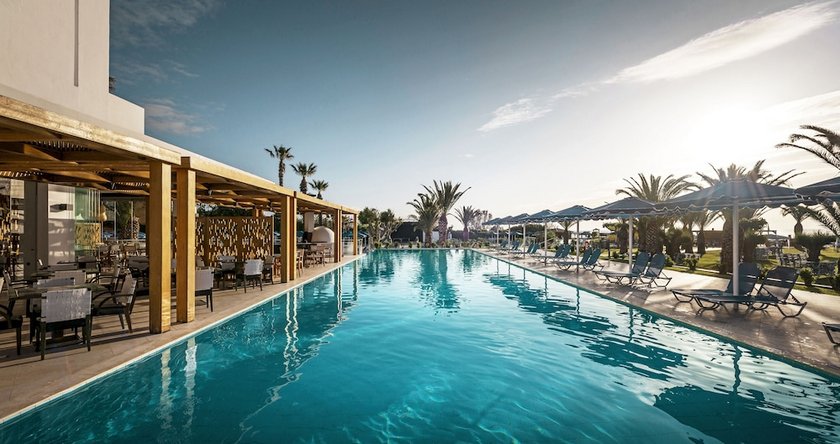 Pool mit Palmen und Sonnenliegen im Mitisis Faliraki Beach Hotel auf Rhodos