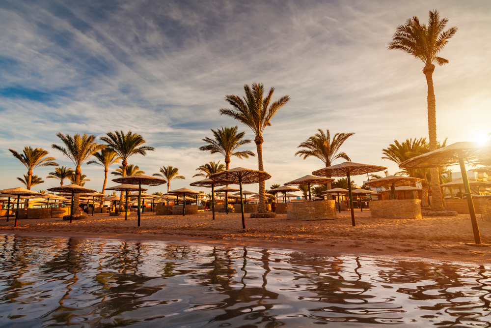 Strand in Hurghada mit Palmen bei Sonnenuntergang