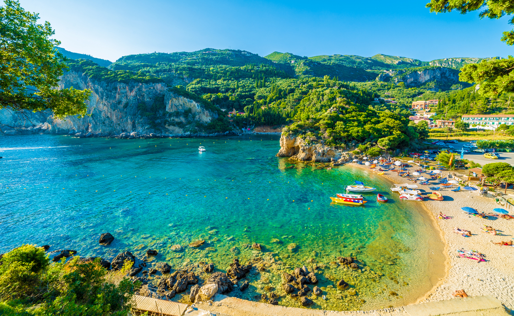 Strand und Bucht Paleokastritsa Korfu mit Urlaubern und Sonnenschirmen