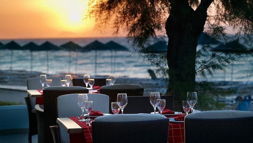 Blick vom Restaurant des Sunrise Hotel auf Rhodos auf den Strand mit Sonnenliegen bei Sonnenuntergang