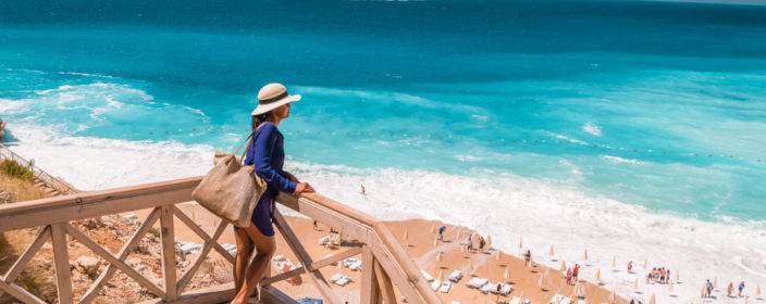 Junge Frau auf einer Treppe am Kaputas Strand in der Tuerkei