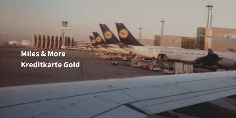 miles and more kreditkarte gold schriftzug vor bild mit Lufthansa Flugzeugen am Flughafen München