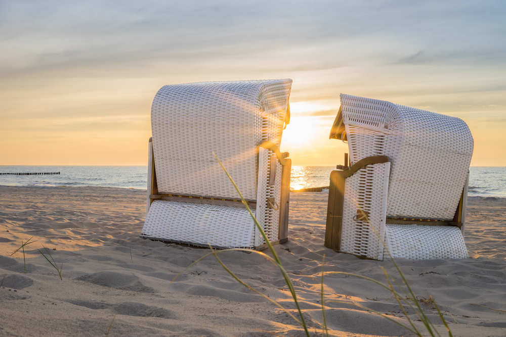 Sonnenuntergang hinter zwei Strandkörben an der Ostsee