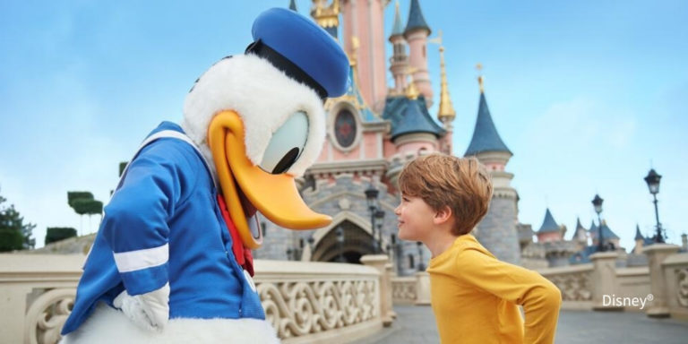 Disneyland Paris Schloss mit Donald Duck und kleinem Kind die sich gegenüberstehen