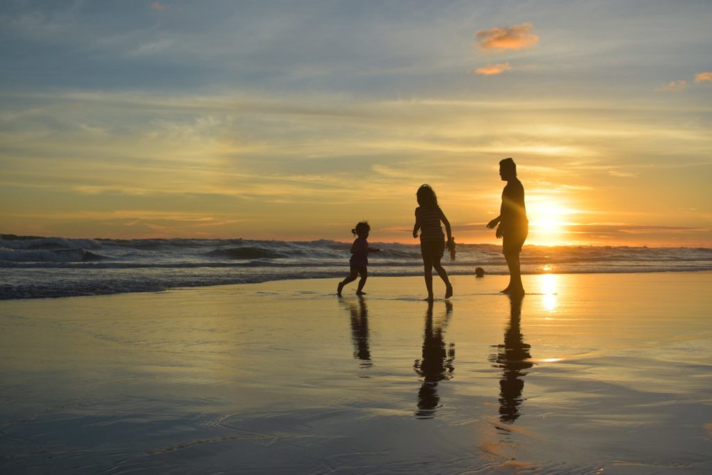 Familie am Strand bei Sonnenuntergang