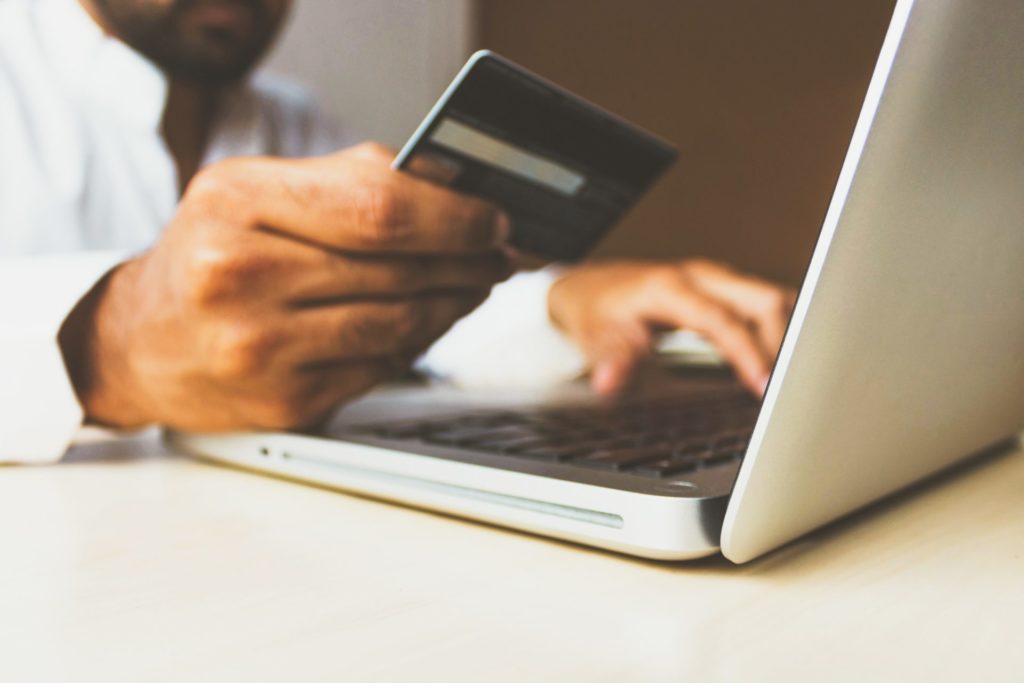Mann bezahlt mit Kreditkarte online
