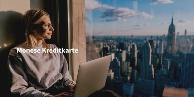 monese kreditkarte Infoseite Schriftzug auf Foto von junger Frau mit Laptop an Fenster mit Blick auf Manhattan
