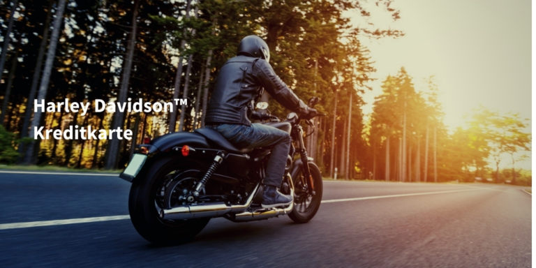 harley davidson kreditkarte schriftzug auf Bild mit Motorradfahrer, der durch einsame Straße in einem Waldgebiet bei Sonnenuntergang fährt