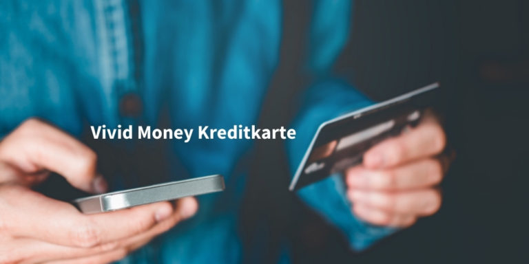 vivd money kreditkarte Schriftzug auf Bild von Nahaufnahme von jungem Mann in Jeanshemd, der eine Kreditkarte und ein Smartphone in seinen Händen hält