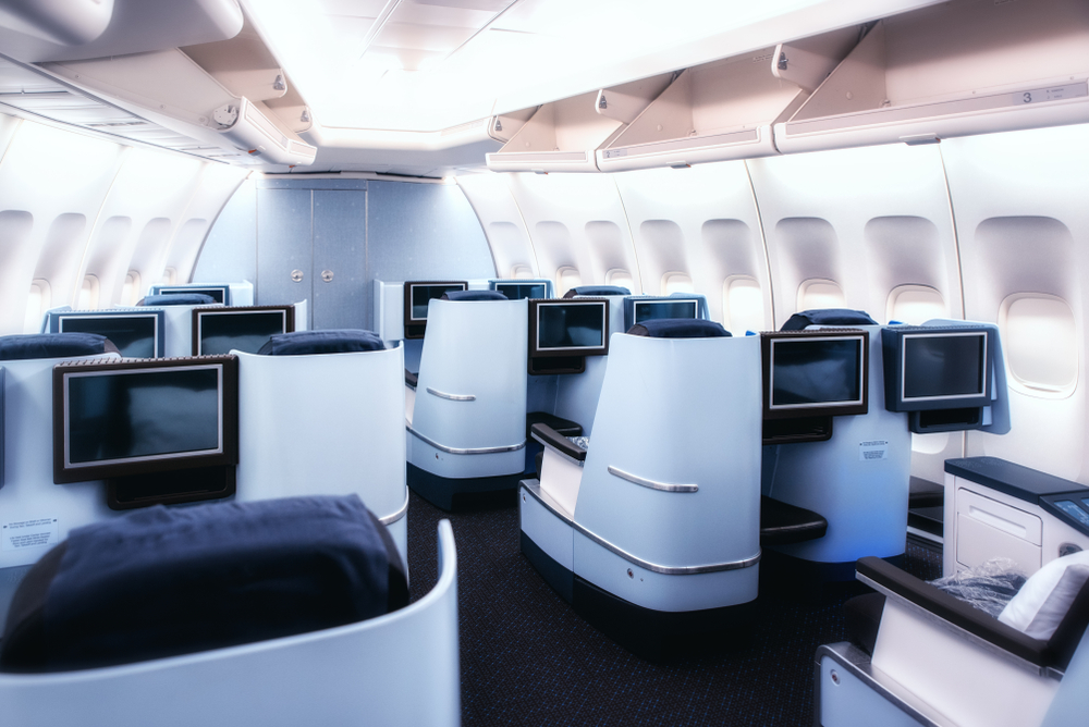 Flugzeugkabine in der Business-Class mit komfortablen Sitzen und großen Bildschirmen