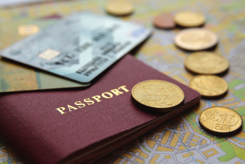 Nahaufnahme von Kreditkarten auf Reisepass mit Kleingeld