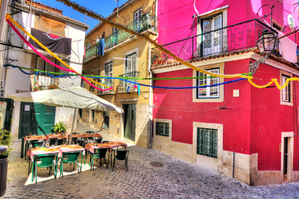 Portugal, Lissabon, Farbenfrohe Gasse mit Lokal