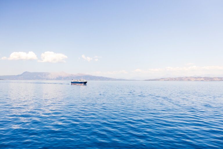 Ferry,Boat,Sailing,In,The,Distance,Over,Still,Ocean,Water