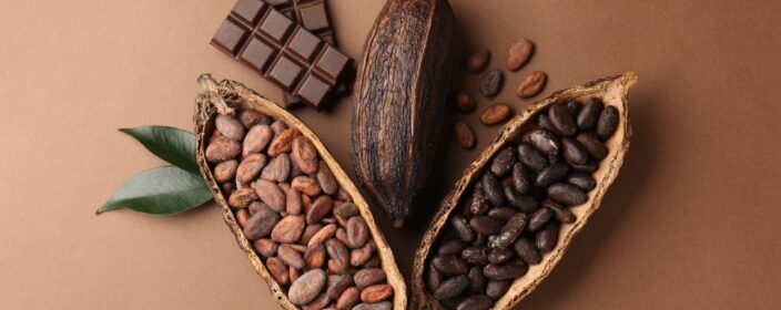 Cocoa,Pods,With,Beans,,Chocolate,And,Leaves,On,Brown,Background,
